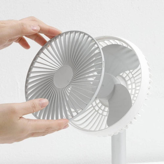 Small gray fan held by a hand on a white background