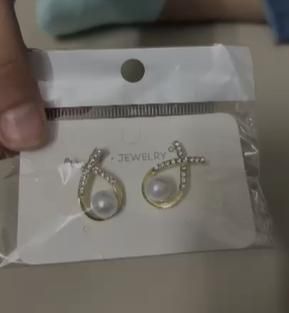 Korean cross pearl stud earrings with gold-plated finish and sparkling stones shown in clear jewelry packaging, elegant and stylish design for women