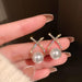 Korean style gold-plated stud earrings with sparkling cross design, studded stones, and pearl embellishments for elegant fashion and party wear