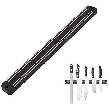Magnetic wall-mounted knife strip holding assorted kitchen knives and tools, providing organized storage and easy access for modern kitchens